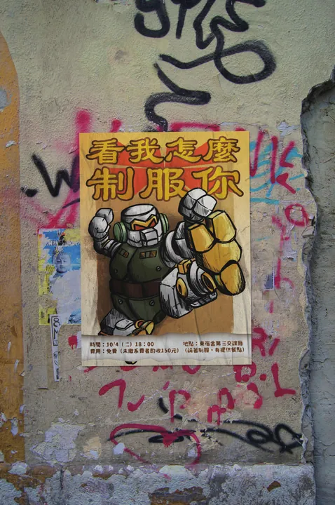 貼在塗鴉牆上的海報，一個機器人擺出出拳姿勢